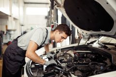 Safety sirst: a good-looking car mechanic is checking the engine
